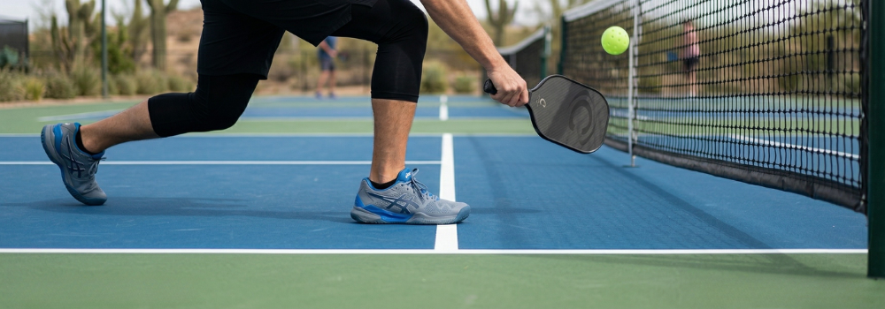 A close-up, ground-level shot of a player's athletic shoes perfectly positioned just a fraction of an inch behind the painted kitchen line